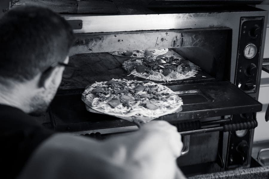 Pizzas baking inside the stone oven